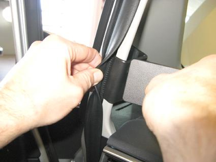 Bild visar en hand som håller i en gummilist vid en bils dörr.