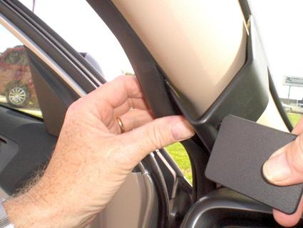 En hand visar en del av interiören i en Kia Optima.