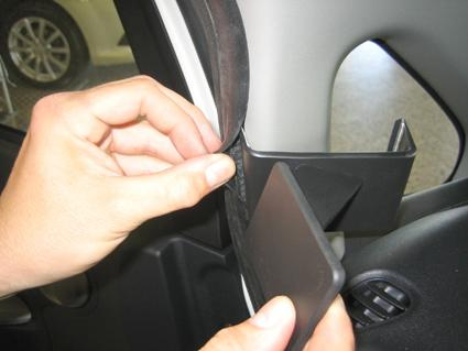 En hand justerar en gummilist vid dörröppningen på en Mitsubishi i-MiEV.