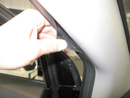 En hand som tar bort en plastdel vid vänster dörr i en Chevrolet Captiva.