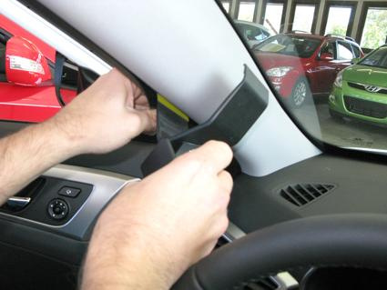 Händer som installerar en monteringsbygel i en bil.