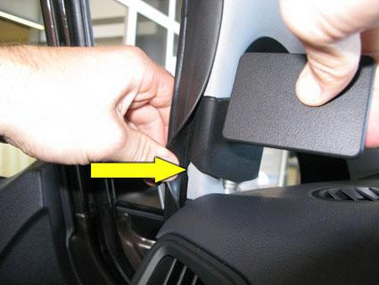 En hand monterar en del på vänster sida av en Kia Rio 12-15.