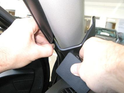 Två händer som justerar eller tar bort en delar i bilen, troligen från Kia Picanto.