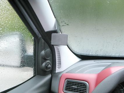 En bilinteriör med regn på fönstret och en kontrollpanel.