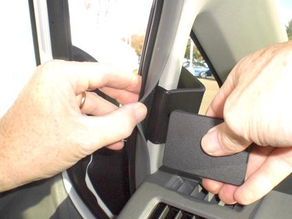 Händer som justerar ett objekt på insidan av en Toyota Prius.