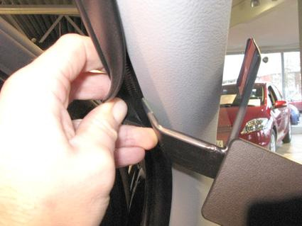 En hand som håller i en gummikant vid en bils insida.