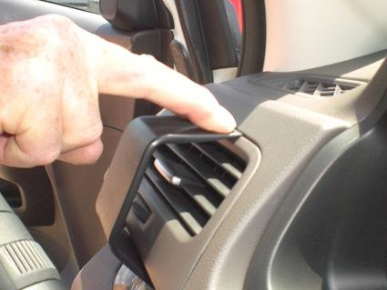 En hand trycker på luftutblåsningen i en Honda CR-V.