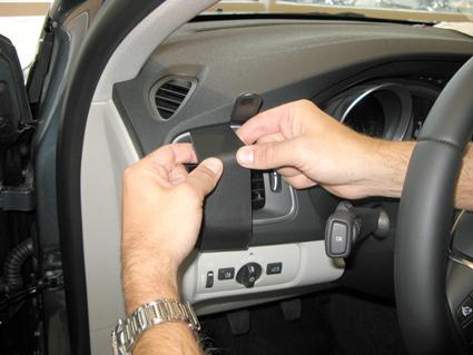 Hand som håller en del av instrumentpanelen i en Volvo V40.