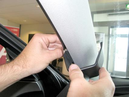 En person installerar en del på en Audi A6, vänster sida.