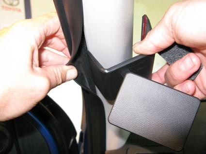 Händer som installerar en del på Toyota HiLux, vänster sida av fordonet.