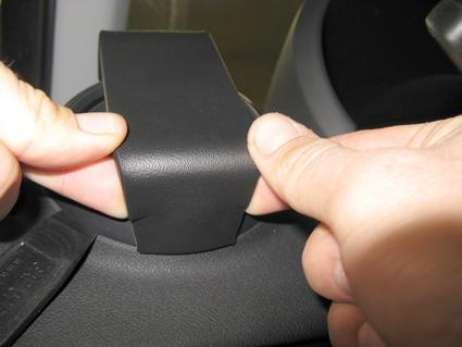 En hand som håller i en svart del av interiören i en Audi A1.