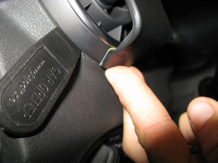 En hand pekar på en del av Audi A1:s interiör.