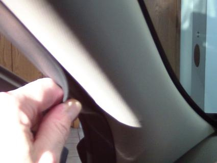 En hand som lyfter en inredningsdel i en bil, troligen Hyundai Santa Fe.