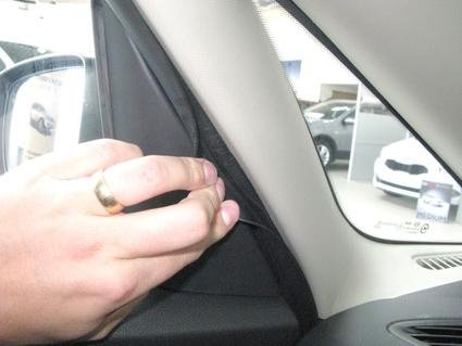En hand justerar en panel i en bilinteriör.