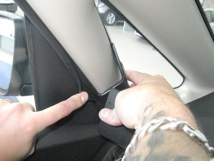 En hand som justerar en panel i en bil.