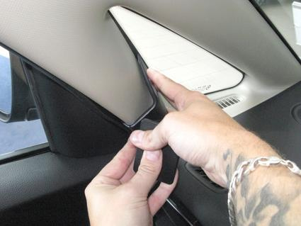 En person demonterar en del av interiören i en Kia Carens.