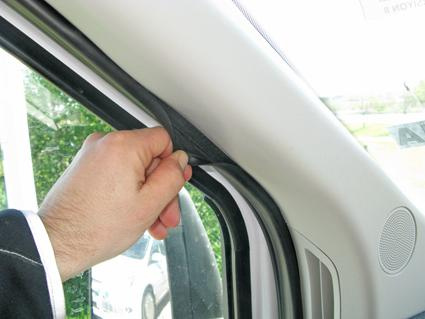 En hand dra i tätningen vid fönstret på en Ford Transit.