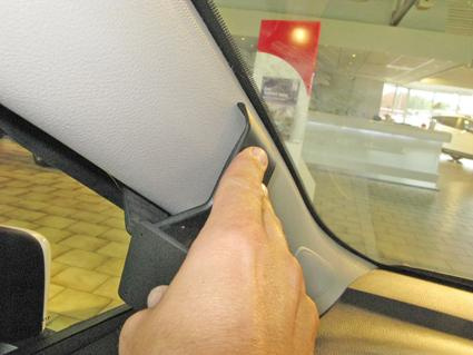 En hand som pekar på en del av inredningen i en Toyota Yaris.