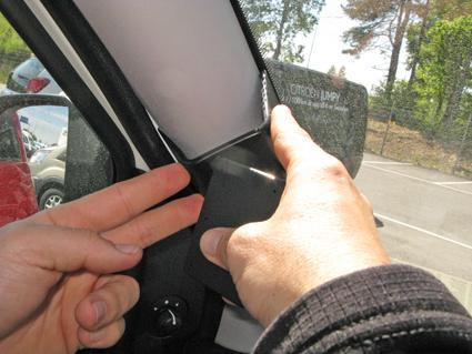 En hand justerar en spegel inuti en Fiat Doblo.