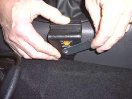 En person installerar en monteringsbygel i en bil.