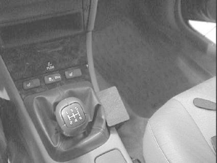 Konsol med växelspak, knappar och del av bilens interiör.