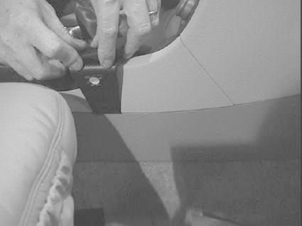 Händer som justerar eller installerar en konsol i en Volvo S80.