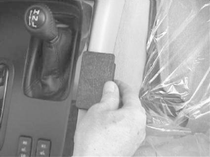 Konsol med växelspak och handen som håller i en del.