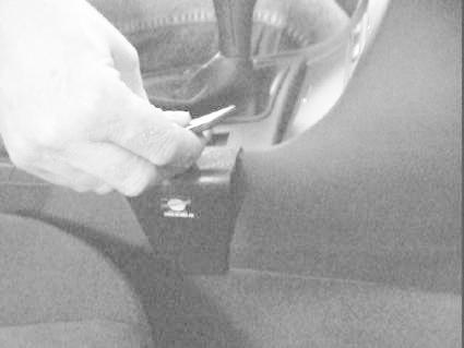 En hand installerar en vinklad konsol i en BMW E46.