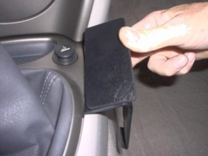 En hand som håller en svart konsolbit för Citroen C5 01-05.