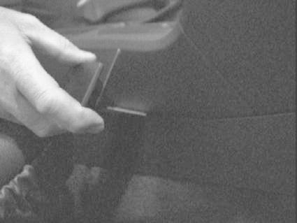 En hand som justerar en konsol i en Volvo V70 00-04.