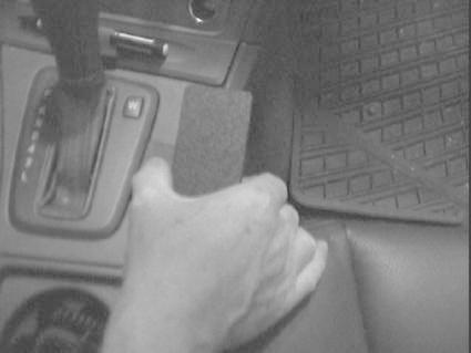 Hand som greppar en växelspak i en bil, troligen en Volvo V70.