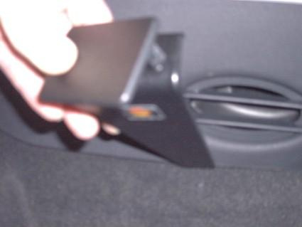 En hand håller en svart konsolbit för Citroen C3/Pluriel 02-04.