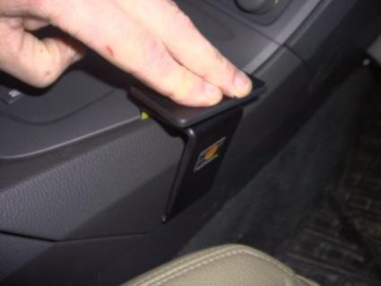 En hand trycker på en konsolknapp i en Volvo S60 00-04.