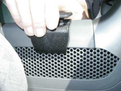 En hand håller en svart konsolbit vid instrumentpanelen i en Honda Pilot.