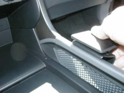 En hand som justerar en komponent i konsolen på en Honda Pilot 03-08.