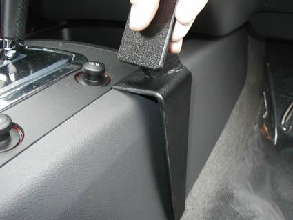 En hand som håller ett svart föremål vid konsolen i en Volkswagen Touareg.