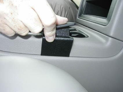 En hand justerar en svart konsol i en Chevrolet Avalanche.