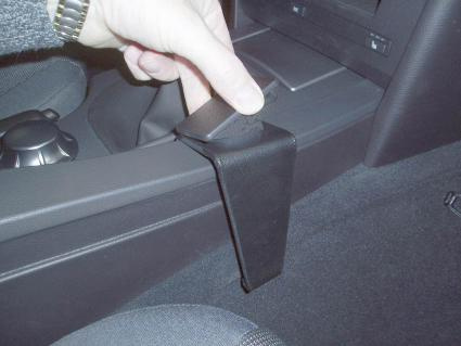 En hand som håller i en svart plastkonsoldel för BMW E60/E61.