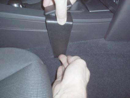 Hand som håller i en konsoldel vid bilen BMW E60/E61.