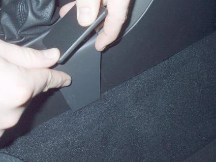 Händer som installerar en konsol i en Subaru Outback 04-06.