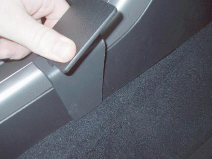 En hand som håller i en bilkonsol för Subaru Outback 04-06.