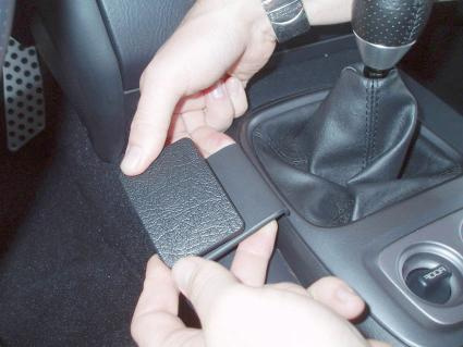 Händer som installerar en monteringsbygel i en bilkonsol.