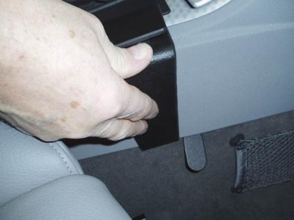 En hand håller i en svart konsol för BMW X3 04-10.