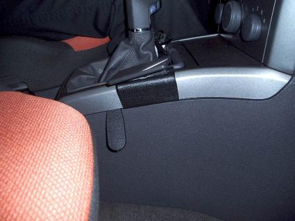 En del av bilens konsol med växelspak och ytor i svart och röd textil.