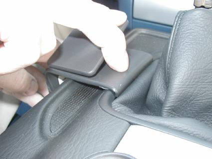 En hand monterar en bygel på en bilkonsol.