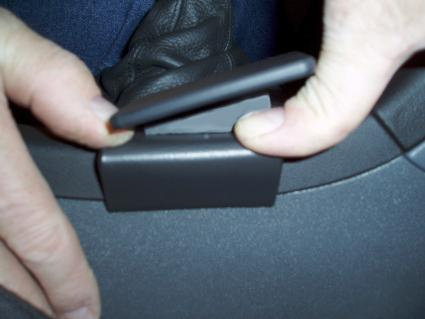 En hand öppnar en konsol lucka i en Saab 9-3.