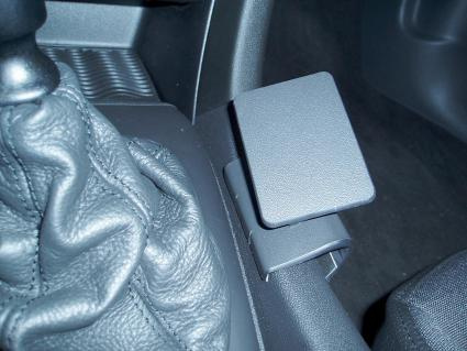 En konsol med en svart platta, placerad nära växelspaken i en Saab 9-3.