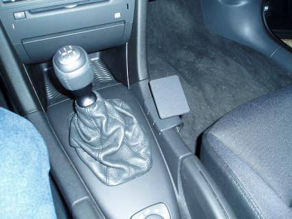 En bilkonsol med växelspak och läderklädd skiftesknapp.