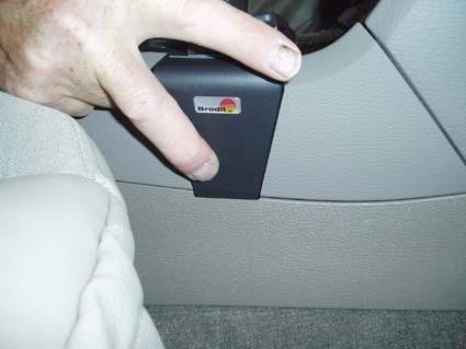 Hand som pekar på en svart konsol-del i en Volvo V70.