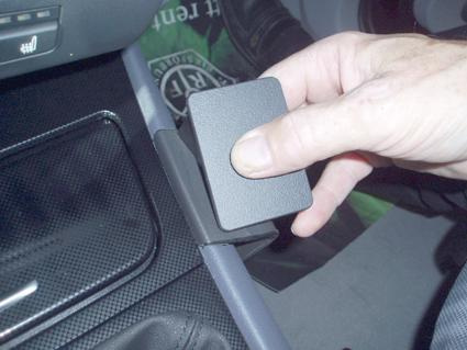 En hand som trycker på en konsol i en BMW-modell.